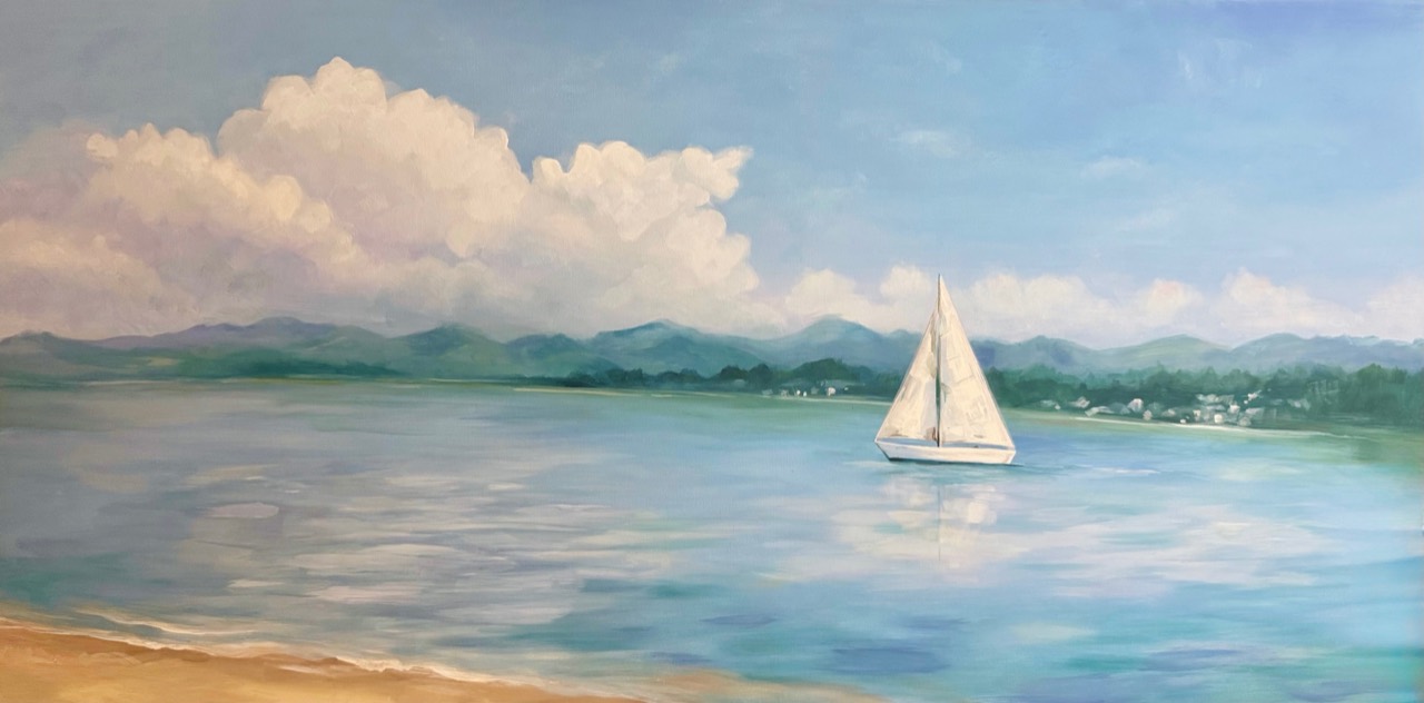 White sailboat on calm blue water beneath clouds and distant green hills